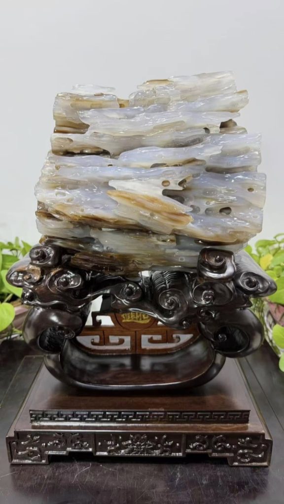 樹化玉擺件，玉化的半透明層理與木紋清晰可見，配紅木雕花底座